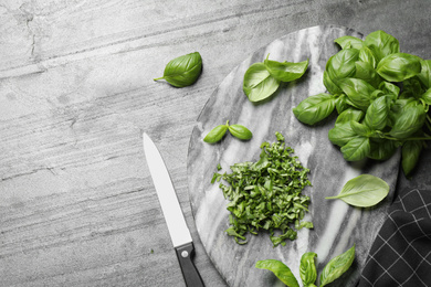 Flat lay composition with fresh basil on light grey table, space for text