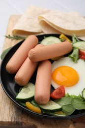 Photo of Delicious breakfast with boiled sausages and fried egg on table, closeup