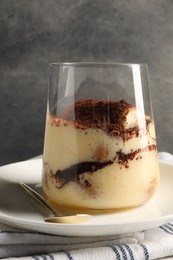 Photo of Delicious tiramisu in glass on table, closeup