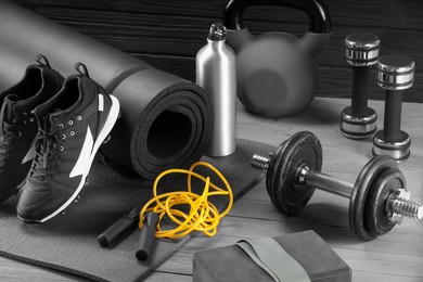 Many different sports equipment on grey wooden table