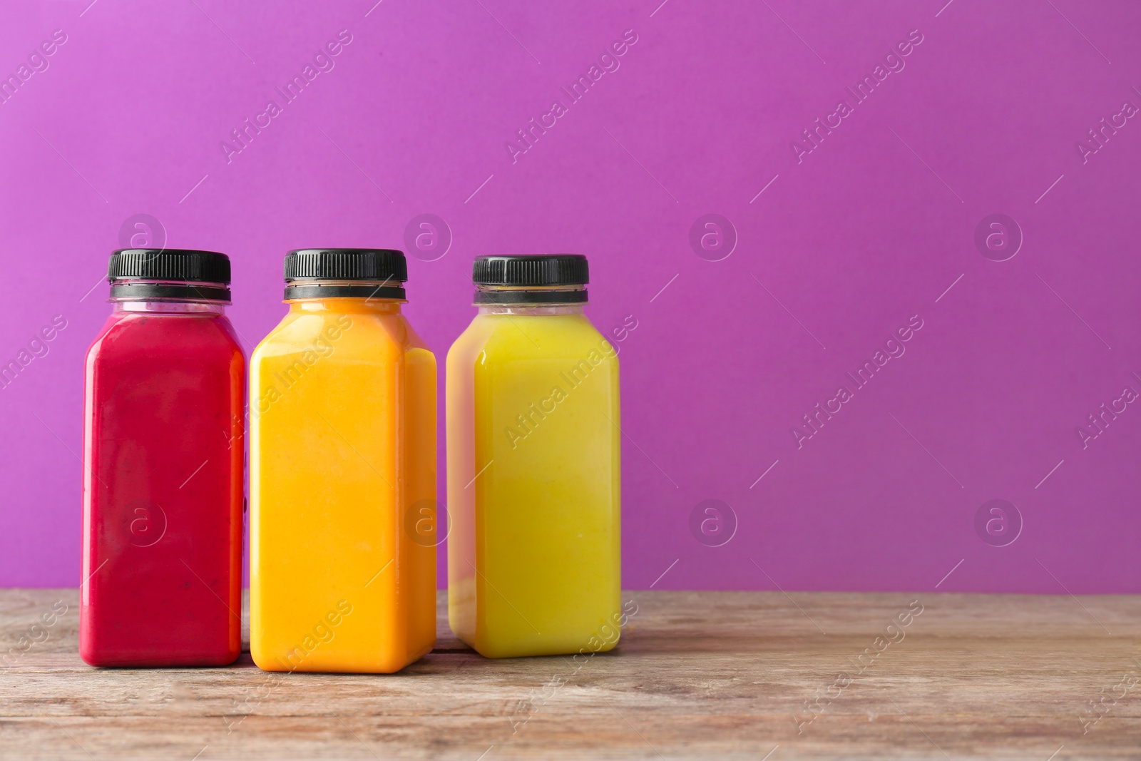 Photo of Bottles with delicious detox smoothies on table