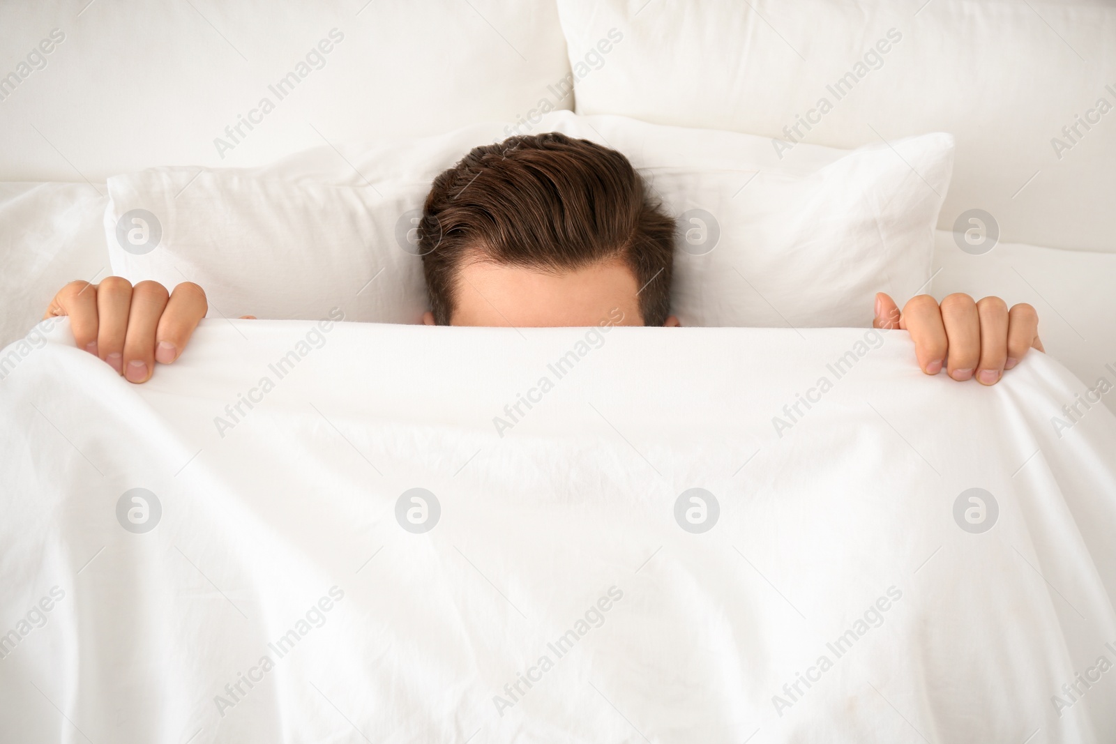 Photo of Man under blanket in bed at home, top view. Lazy morning