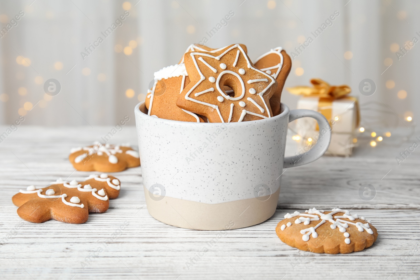 Photo of Cup with tasty homemade Christmas cookies on table