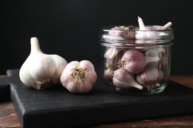 Photo of Many fresh garlic bulbs on wooden table, closeup