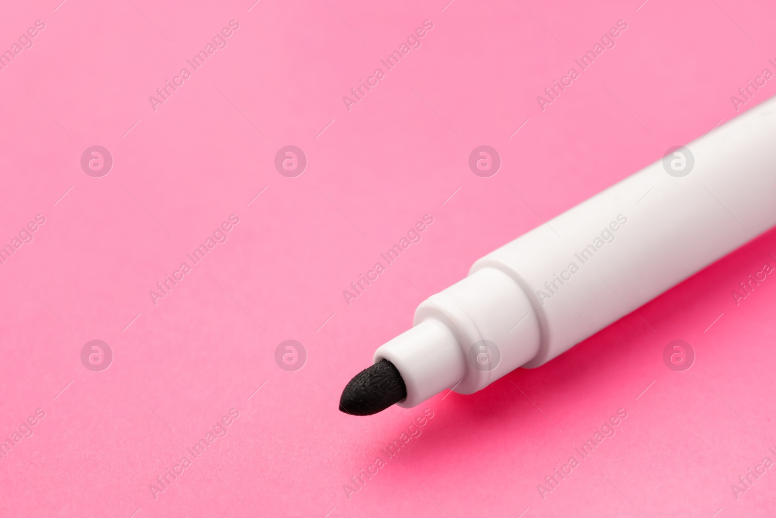 Photo of Black marker on pink background, closeup. Space for text