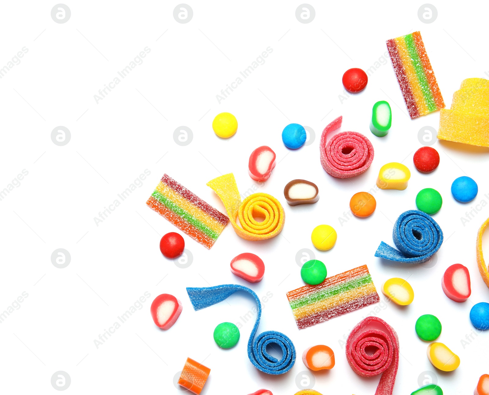 Photo of Many different yummy candies on white background, top view. Space for text