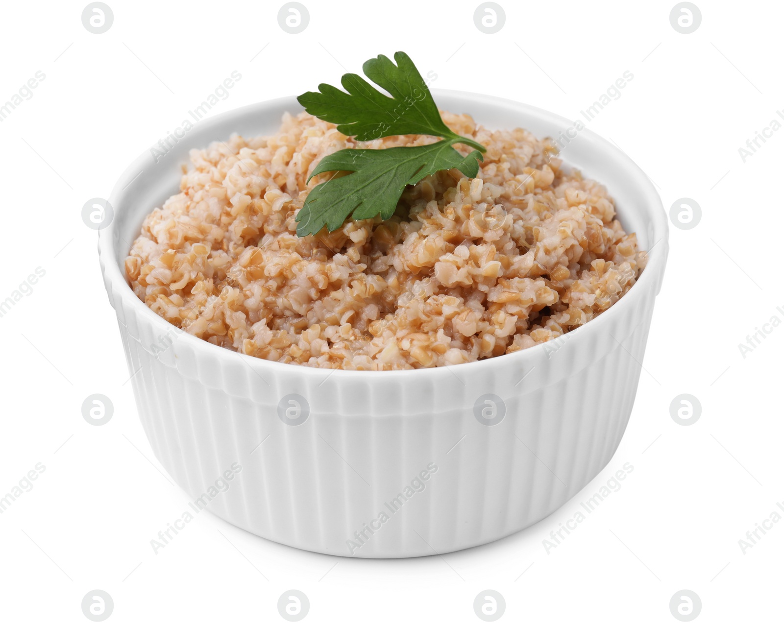 Photo of Tasty wheat porridge with parsley in bowl isolated on white