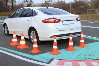 Photo of Modern car on driving school test track with traffic cones