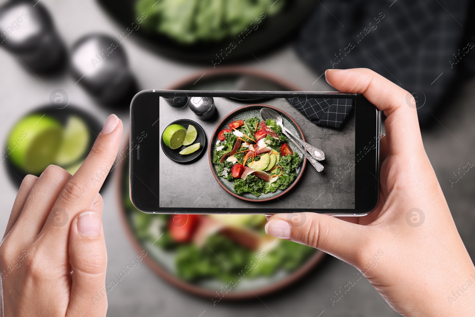 Image of Blogger taking picture of delicious salad with prosciutto at table, closeup. Food photography