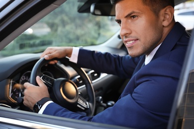 Photo of Handsome man driving his modern car, view from outside