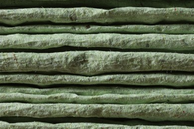 Texture of stacked light green paper napkins as background, macro view