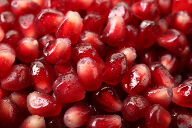 Ripe juicy pomegranate grains with water drops as background, closeup