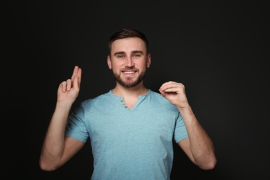 Photo of Man using sign language on black background