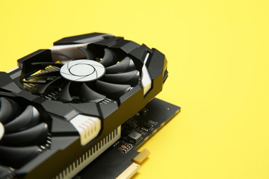Photo of Computer graphics card on yellow background, closeup. Space for text