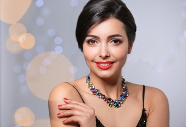 Beautiful woman with elegant jewelry on blurred background