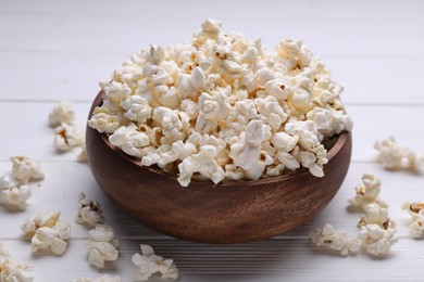Photo of Tasty popcorn on white wooden table, closeup