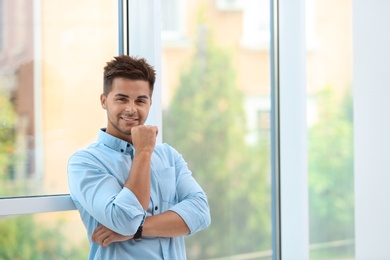 Photo of Portrait of handsome young man near window