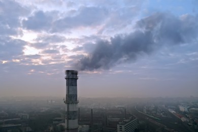 Image of CO2 emissions. Polluting air with smoke from industrial chimney outdoors, aerial view