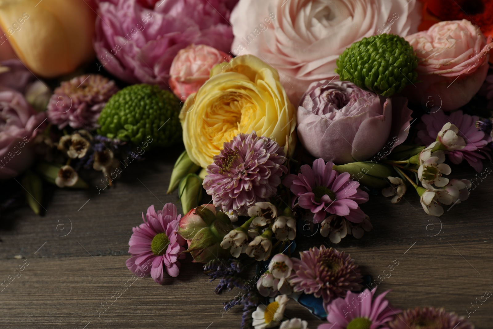 Photo of Bouquet of beautiful flowers on wooden background