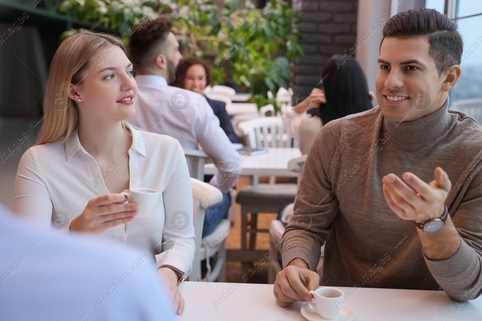 Photo of Group of coworkers having coffee break in cafe