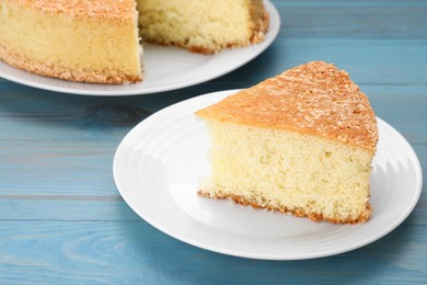 Tasty sponge cake on light blue wooden table