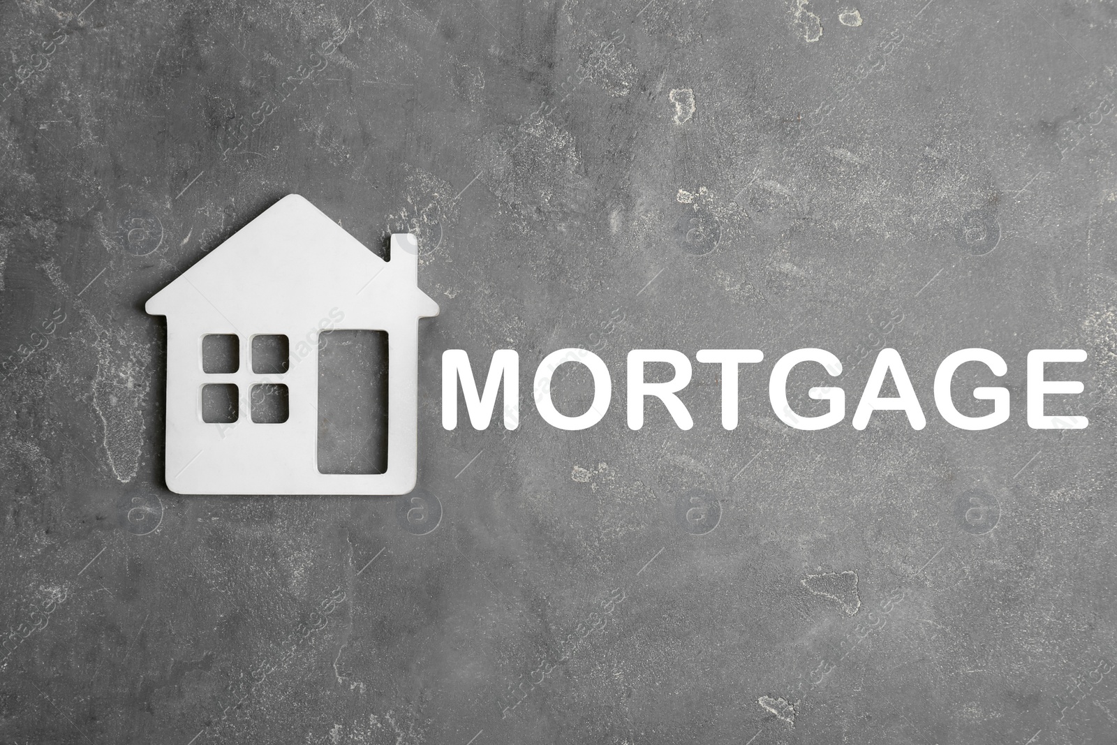 Image of Mortgage concept. House model and grey stone background, top view