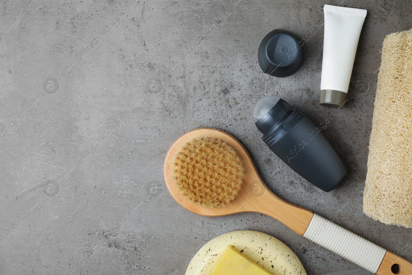 Photo of Flat lay composition with natural deodorant and bath accessories on grey marble table. Space for text