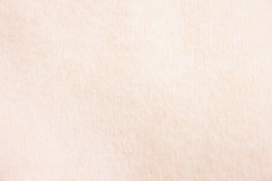 Texture of soft beige sweater as background, top view