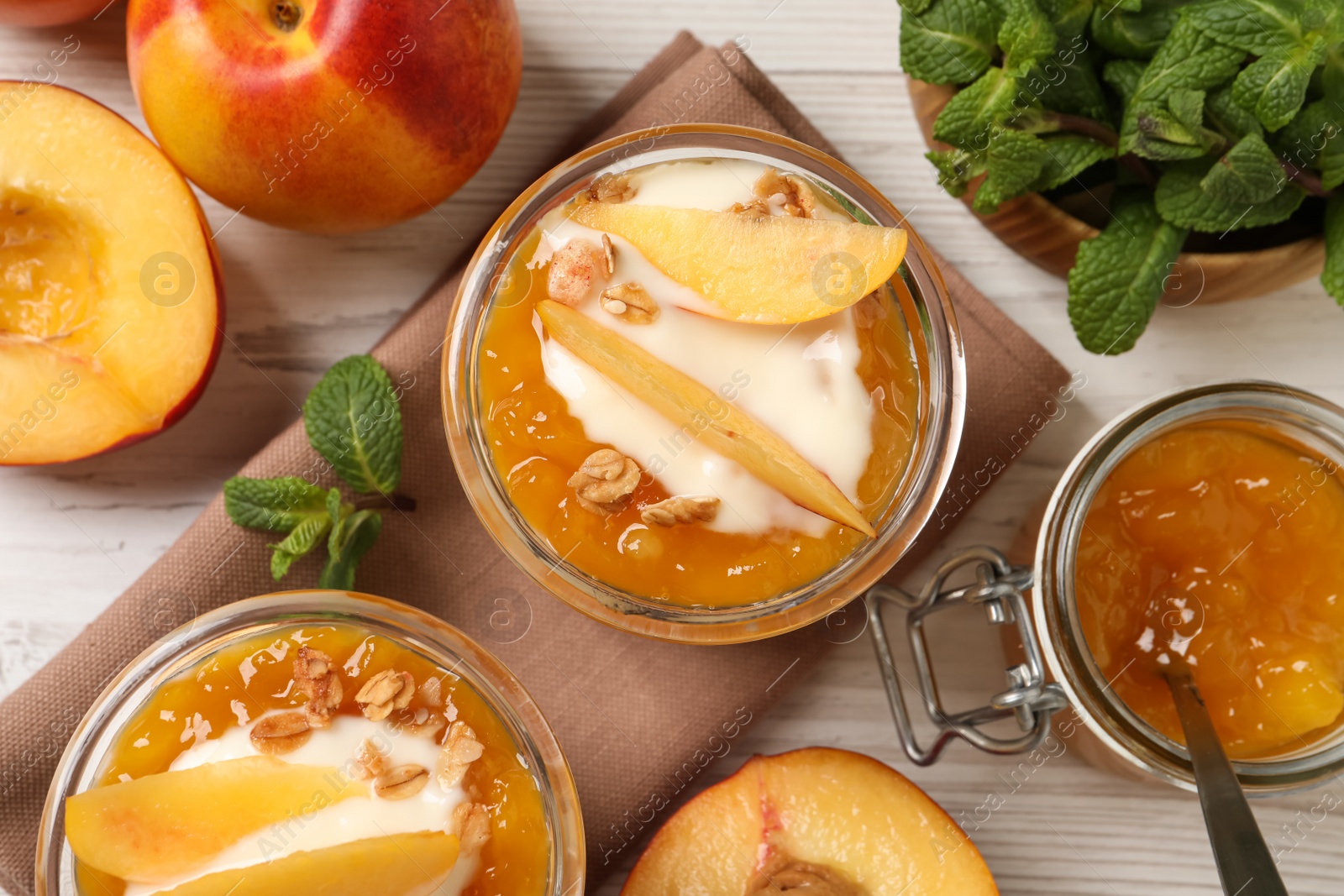 Photo of Flat lay composition with tasty peach yogurt on white wooden table