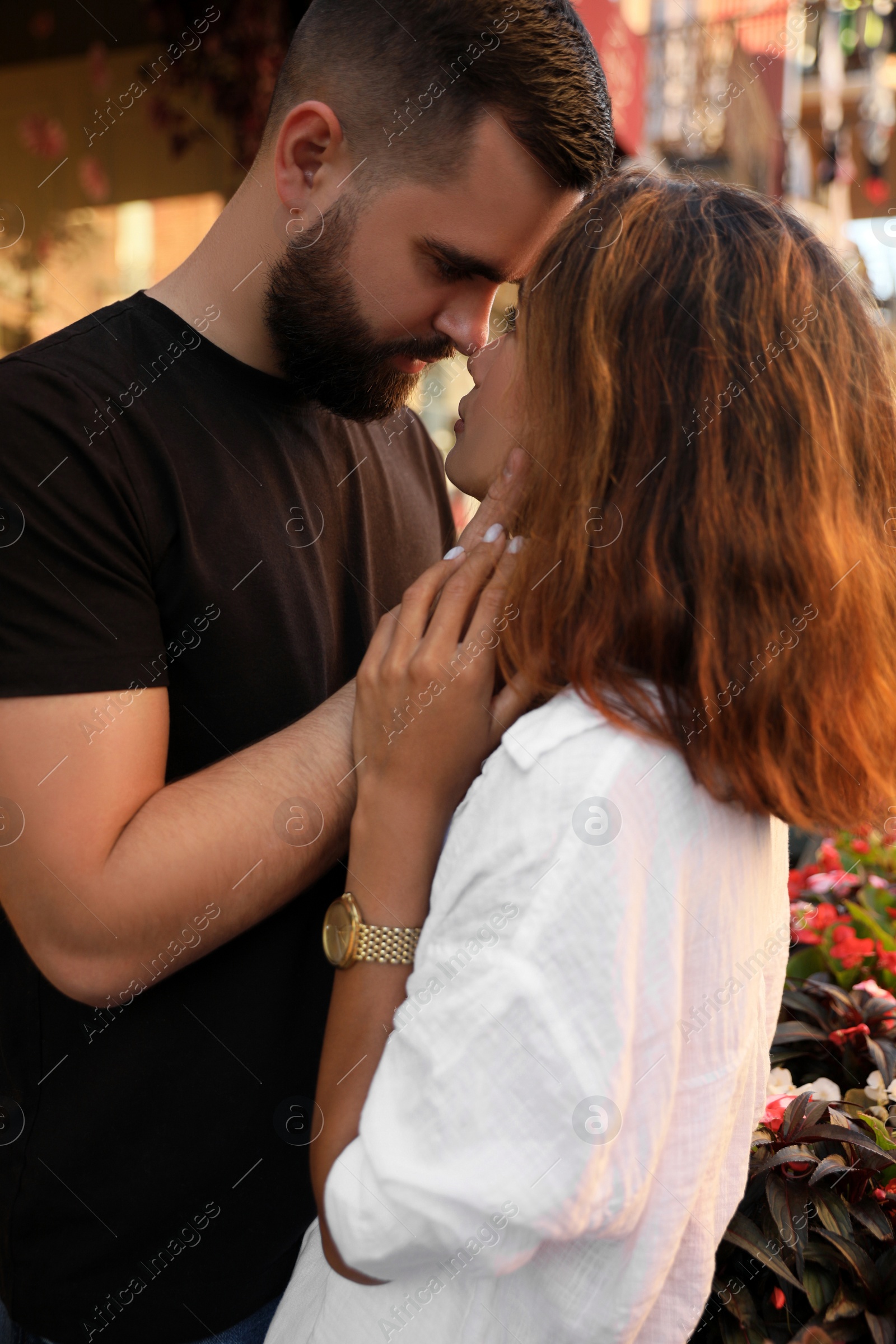 Photo of Happy young couple kissing on city street