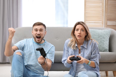 Young couple playing video game at home