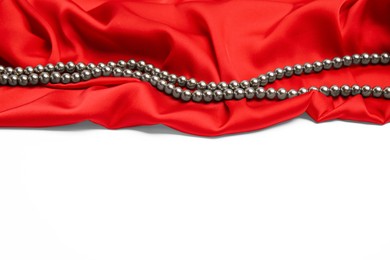 Beautiful pearls and red silk on white background