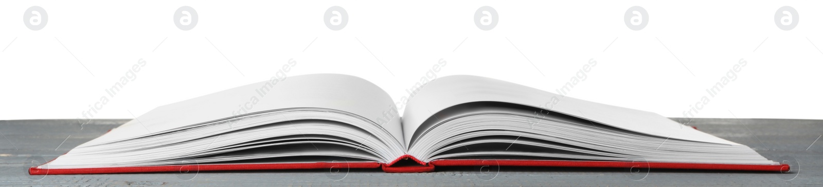 Photo of Open book with red cover on wooden table against white background