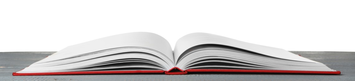 Photo of Open book with red cover on wooden table against white background