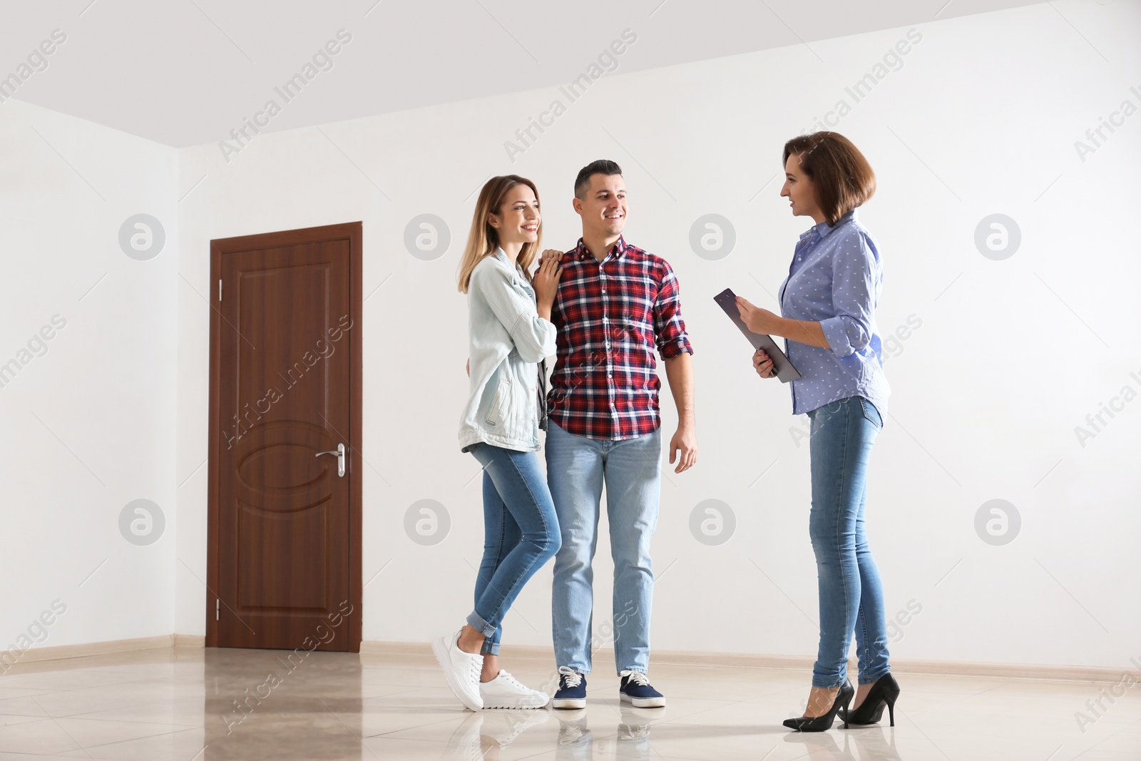 Photo of Real estate agent showing new apartment to young couple