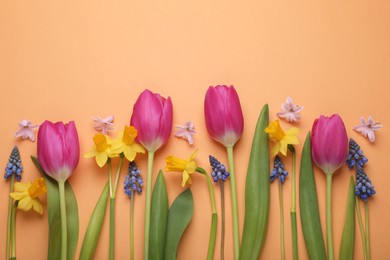 Beautiful different flowers on orange background, flat lay. Space for text