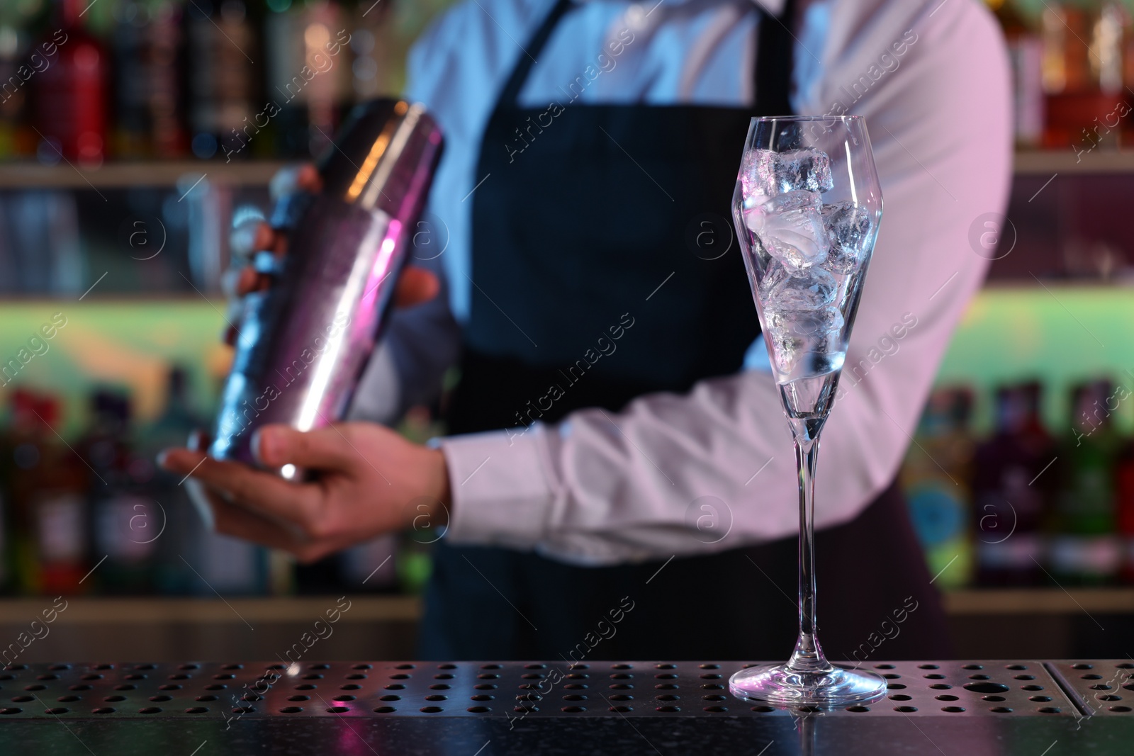 Photo of Bartender making fresh alcoholic cocktail at counter in bar, selective focus