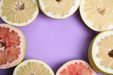 Photo of Frame of different cut pomelo fruits on lilac background, flat lay. Space for text