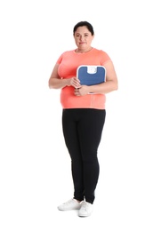 Overweight woman in sportswear with scales on white background