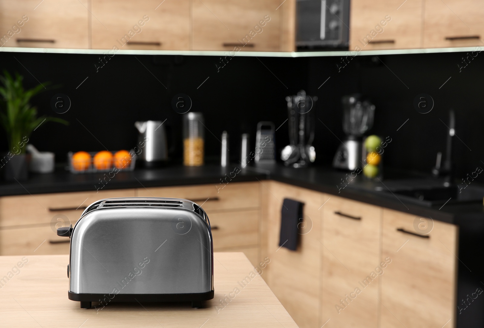 Photo of Modern toaster on table in kitchen, selective focus