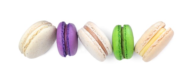 Photo of Different delicious colorful macarons on white background, top view