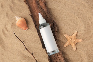 Photo of Flat lay composition with bottle of cream and shells on sand. Cosmetic product
