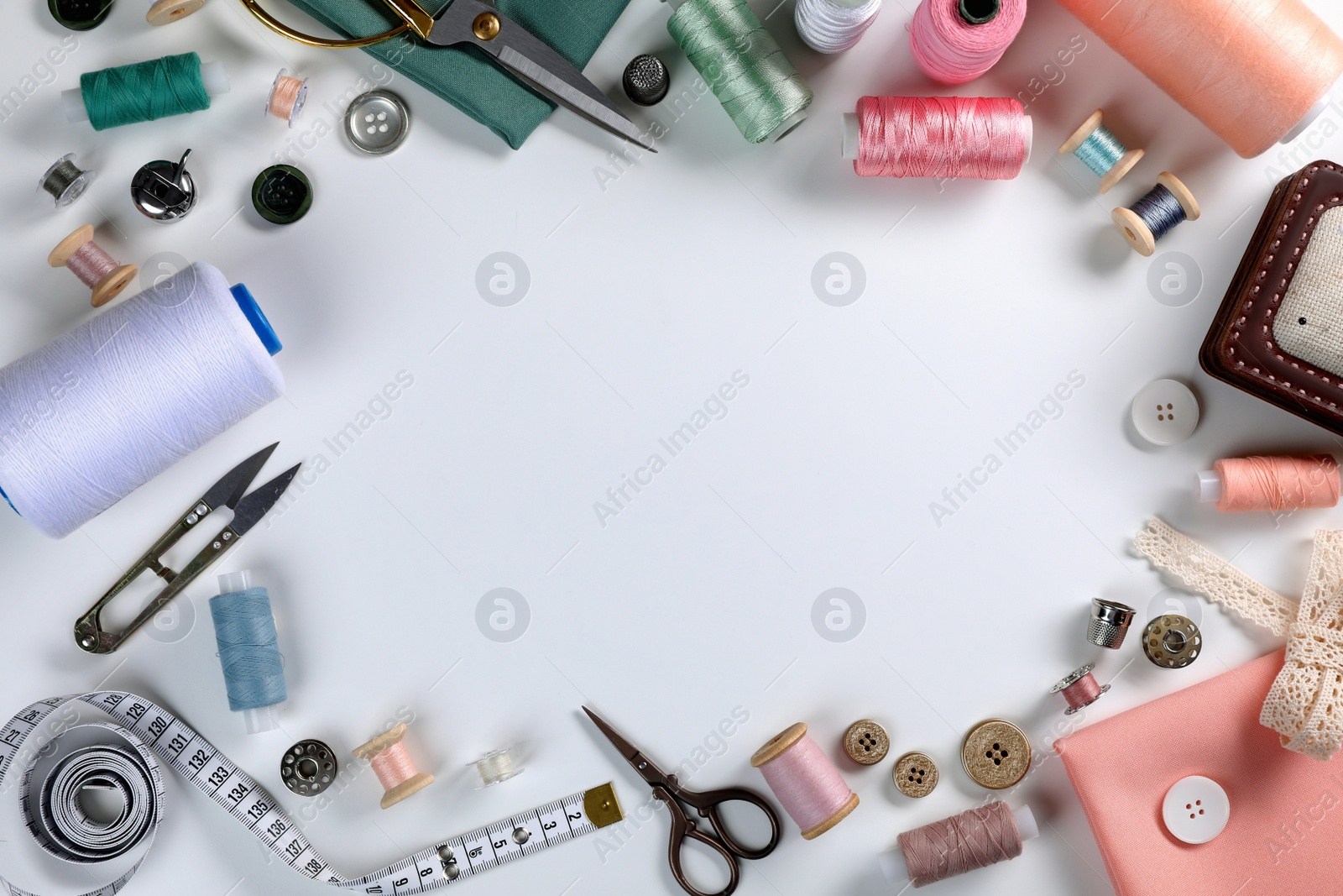 Photo of Different sewing accessories on white background, top view. Space for text