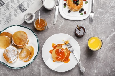 Photo of Delicious pancakes with jam and glass of juice served for breakfast on table