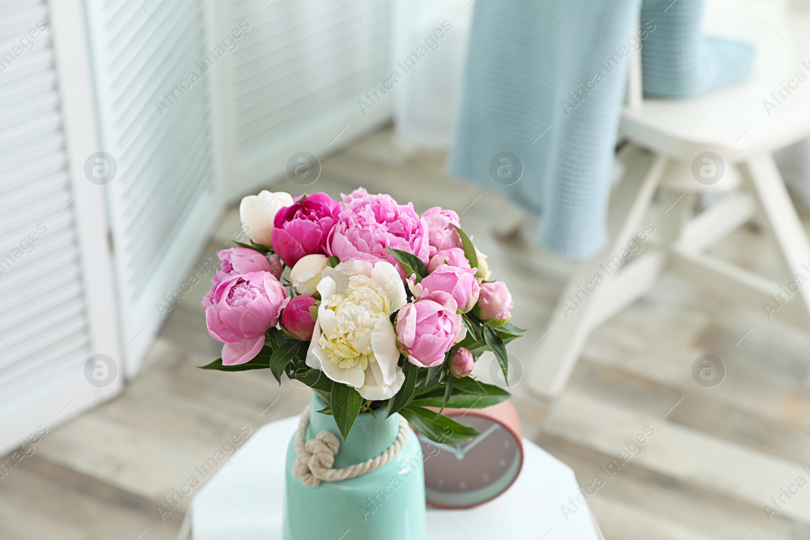 Photo of Vase with bouquet of beautiful peonies on table in room. Space for text