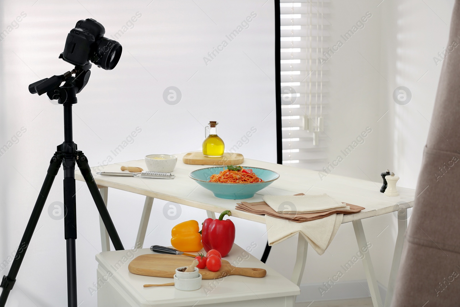 Photo of Professional equipment and composition with delicious spaghetti on white wooden table in studio. Food photography