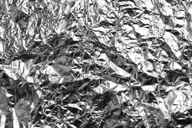 Crumpled silver foil as background, closeup view