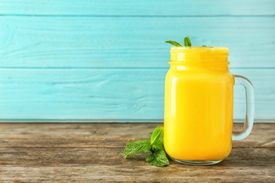 Photo of Mason jar with delicious detox smoothie on table