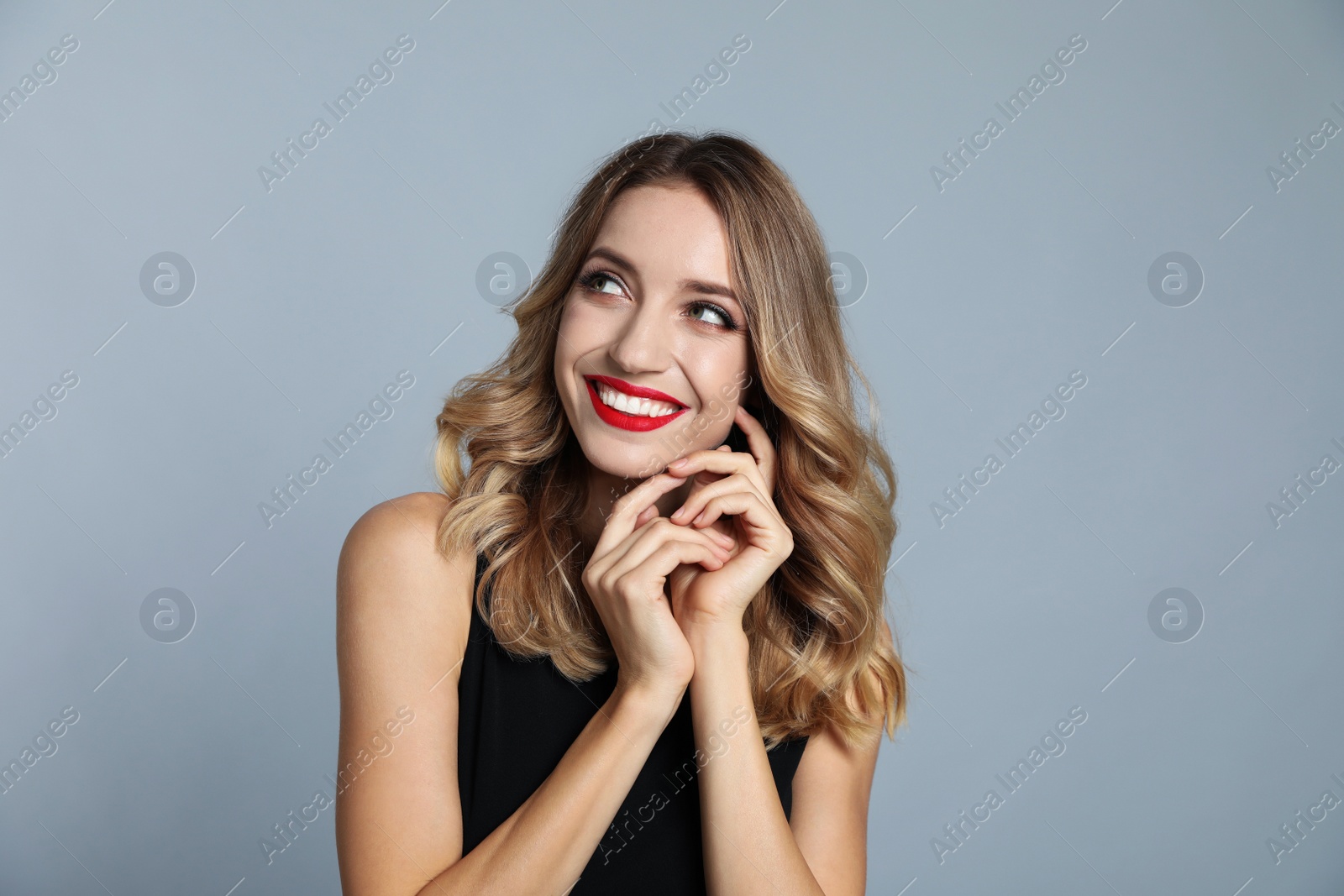 Photo of Happy young woman on grey background. Christmas celebration