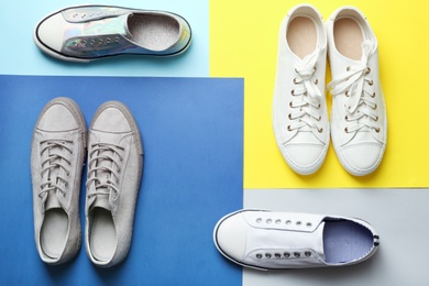 Photo of Flat lay composition with different sneakers on color background